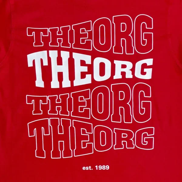 Viermal THEORG in einer wellenförmigen Schrift untereinander auf einem roten Stoff. Das zweite THEORG von oben ist weiß ausgefüllt, die anderen haben eine weißen Konturline. Darunter steht est. 1989.