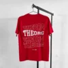 Rotes T-Shirt auf an einem Kleiderbügel an einer Kleiderstange. Der Rückendruck ist viermal THEORG in einer wellenförmigen Schrift untereinander. Das zweite THEORG von oben ist weiß ausgefüllt, die anderen haben eine weißen Konturline. Darunter steht est. 1989.